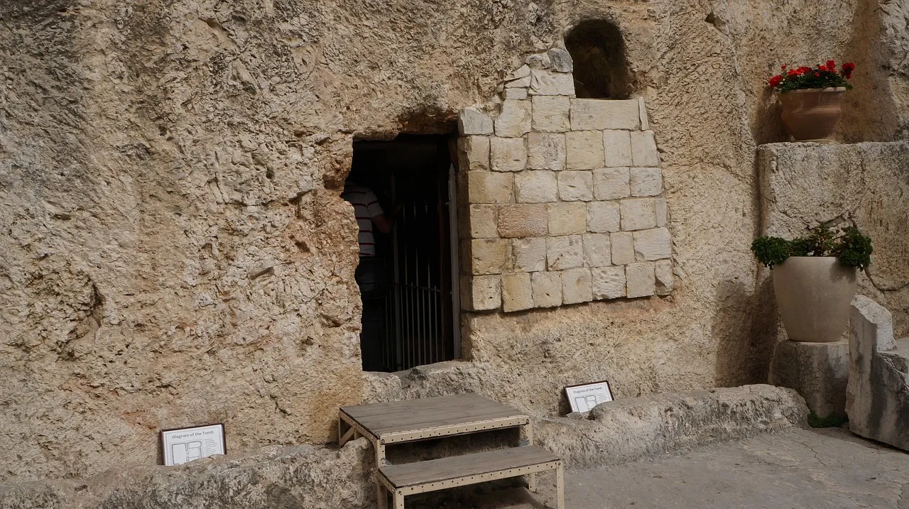 Interior view of the Garden Tomb's rock-cut burial chamber with morning light falling on the stone shelf
